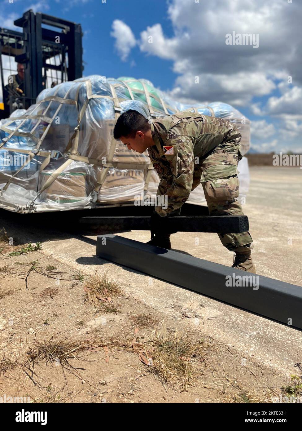 An U.S. Airman places a piece of wood underneath a pallet of medical supplies delivered in support of Pacific Angel 22-4 at Baucau City Airport, Timor-Leste, Sept. 11, 2022. The operation, scheduled for Sept.12-17, will focus on capacity building through health services outreach, engineering civic action program construction projects and subject matter expert exchanges. Stock Photo