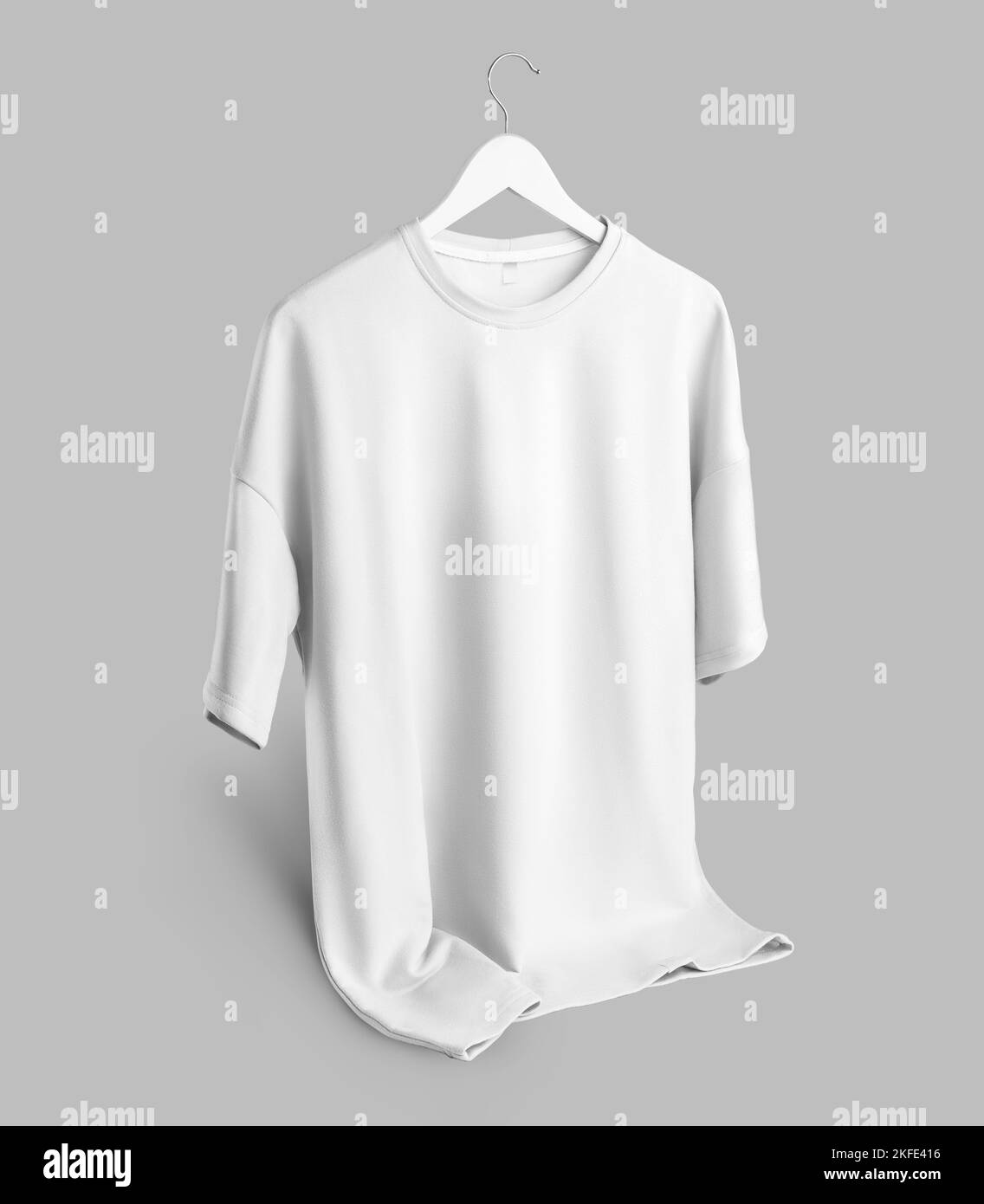 Mockup of an oversized white t-shirt with a round neckline hanging on a hanger with the bottom turned up, isolated on background, front view. Blank cl Stock Photo