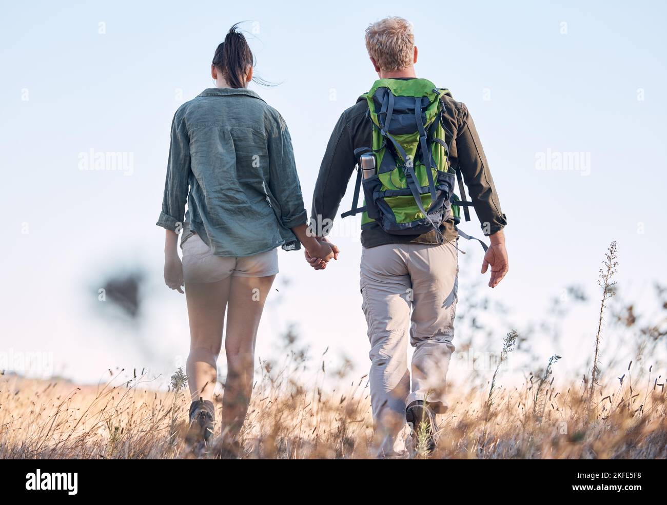 Couple, holding hands and travel or backpack adventure in bonding relationship together in the countryside. Hands of man and woman backpacking Stock Photo