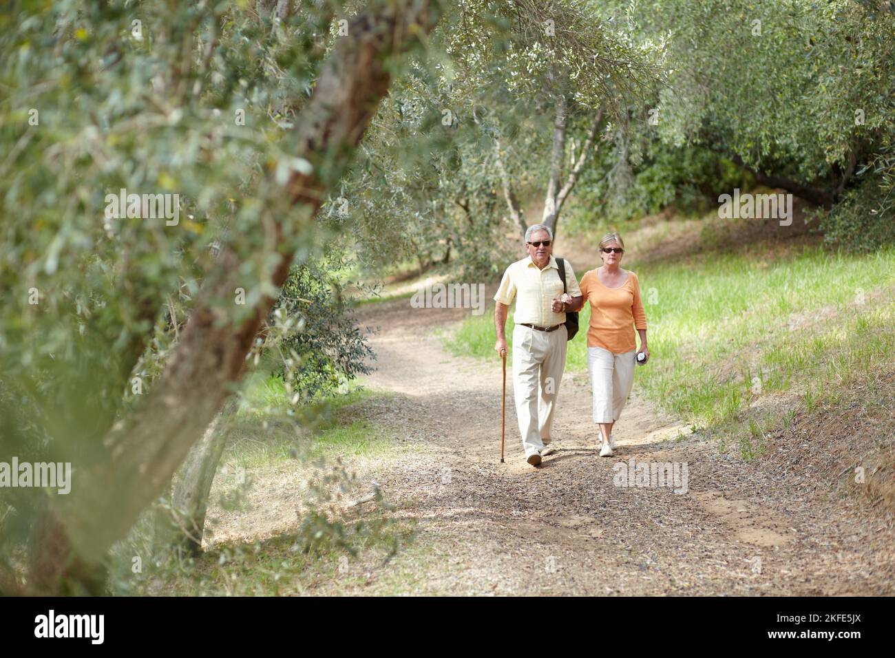 Enjoying a day out in nature. A senior couple walking together along a ...