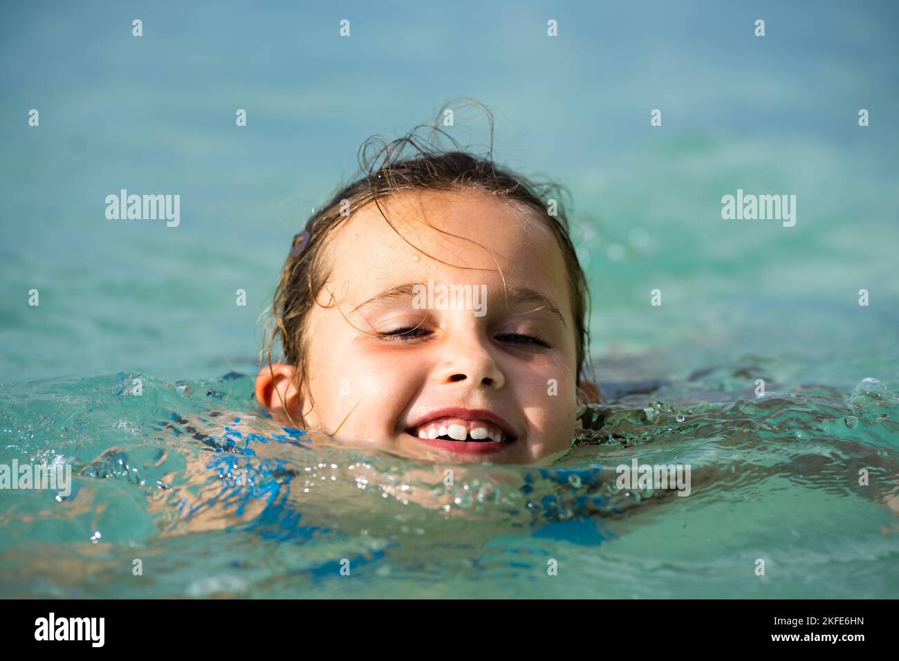 Happy Kid Learning Swimming With Swimming Disc Or Ring In Water. Child