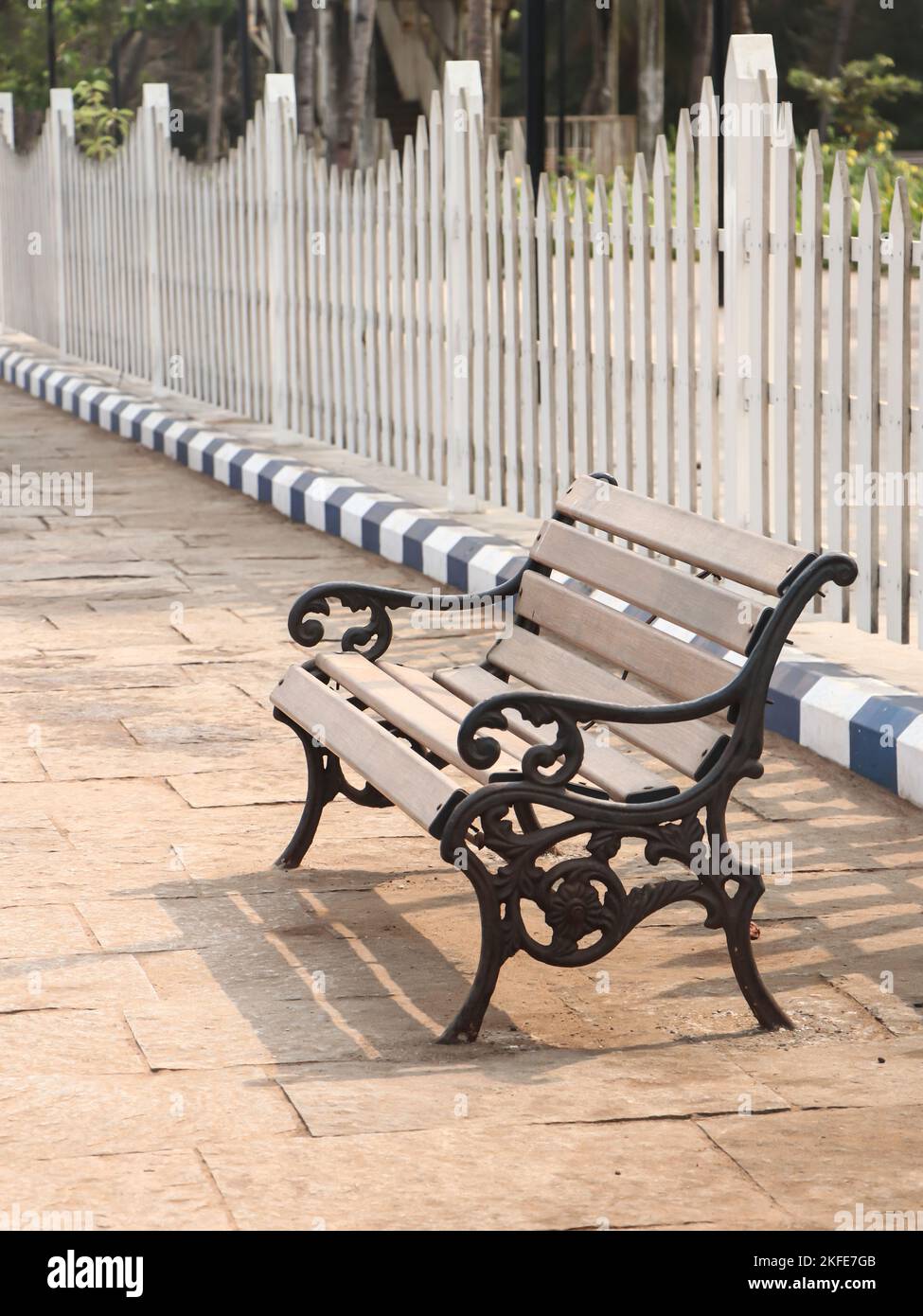 an empty bench with simple design in a very clean park during daytime Stock Photo