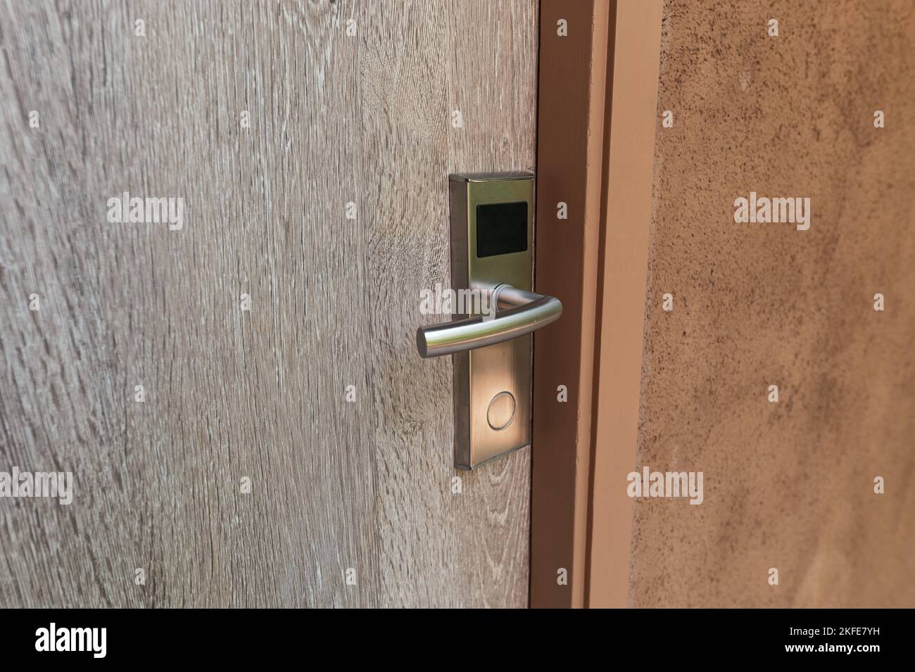 Digital door lock with key card entry system on wooden door Stock Photo