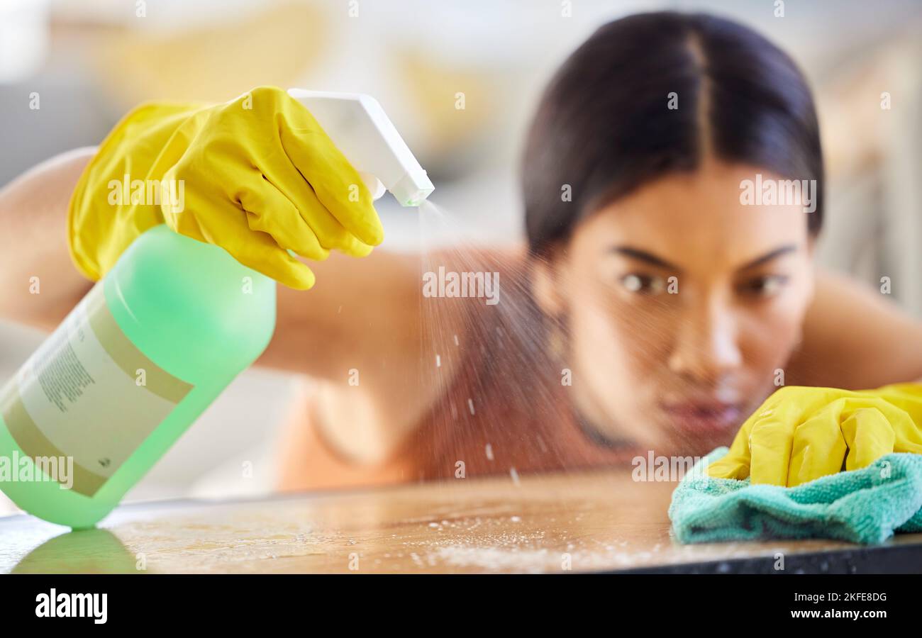Spray bottle, cloth and woman cleaning table from bacteria, germs or dirt with disinfectant liquid. Housekeeping, hygiene and maid or cleaner with Stock Photo
