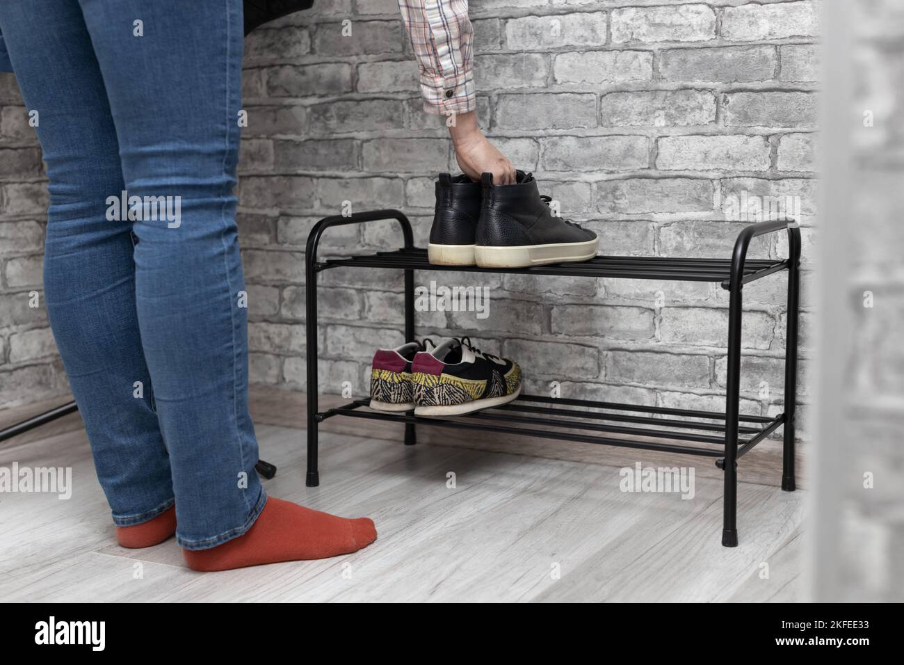 a woman puts shoes in a shoebox when she comes home. woman putting on shoes Stock Photo