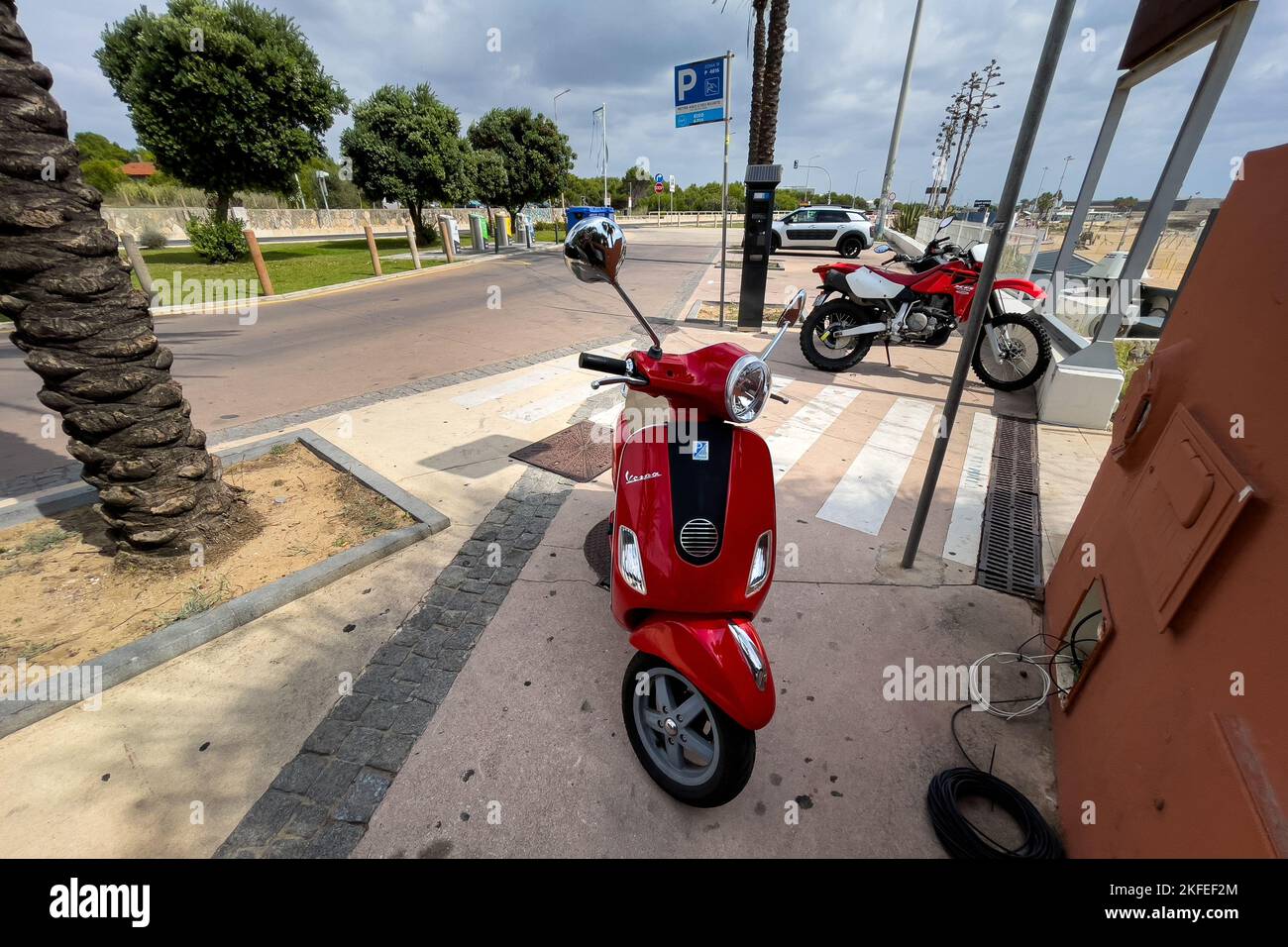 Red Vespa scooter parked on the street Stock Photo