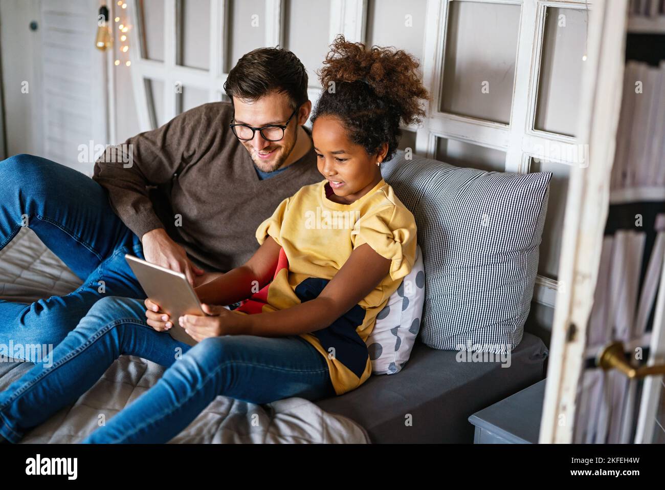 Happy multiethnic single parent studying with child at home Stock Photo