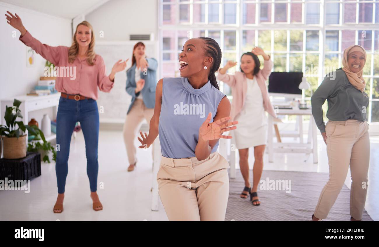 Business, women and group dance for fun celebration in a creative office for campaign success with diverse staff. Joy, excitement and dancing with a Stock Photo