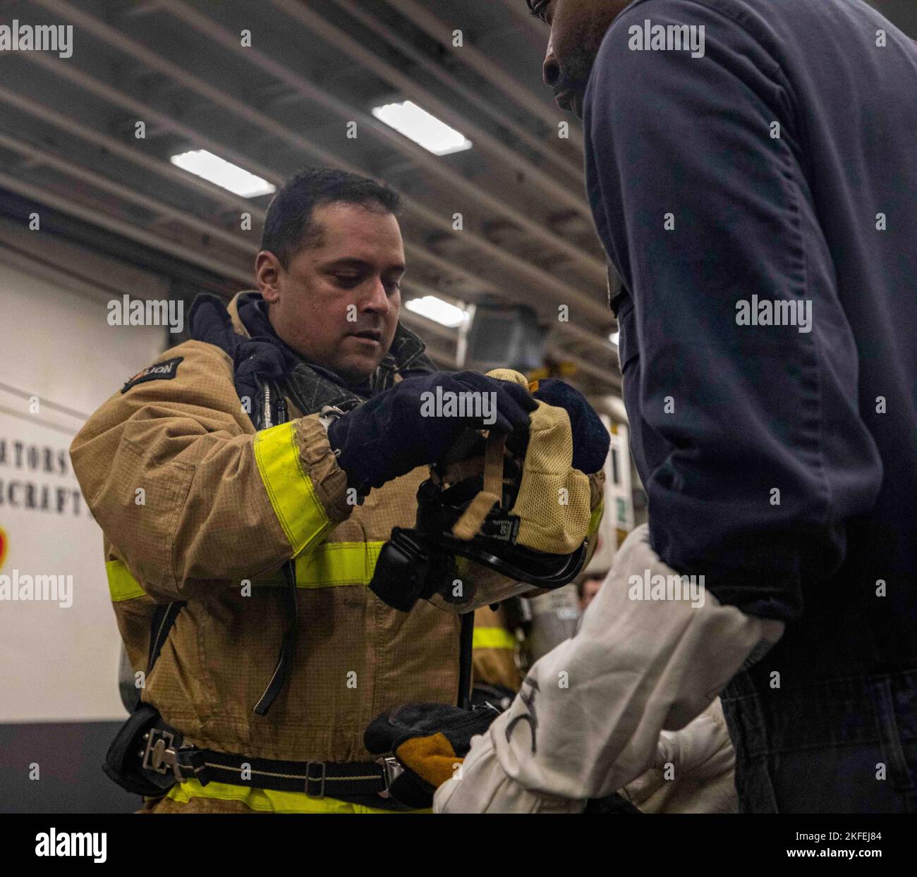 220912-N-DP708-1402    PACIFIC OCEAN (Sept. 12, 2022) – Electrician’s Mate Senior Chief Chris Rodriguez, left, and Damage Controlman 2nd Class James King don firefighting gear during a general quarters drill aboard amphibious assault ship USS Makin Island (LHD 8), Sept. 12. Damage control drills are used both in port and underway to ensure that Sailors have the proper training to combat any casualty that may arise. The Makin Island Amphibious Ready Group, comprised of amphibious assault ship USS Makin Island (LHD 8) and amphibious transport docks USS Anchorage (LPD 23) and USS John P. Murtha ( Stock Photo