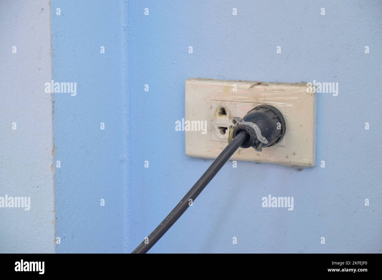 The power plug is plugged into the wall outlet Stock Photo Alamy
