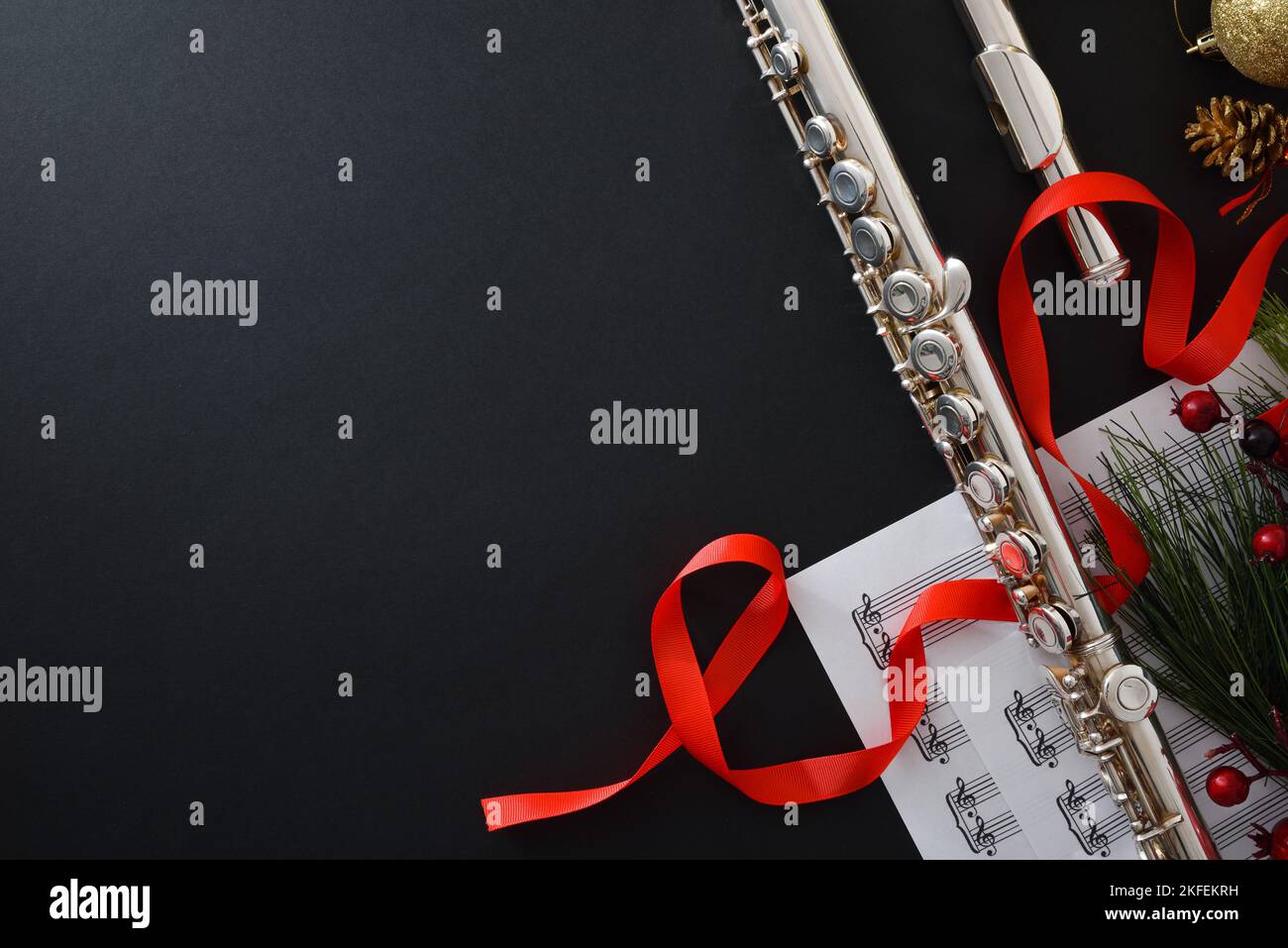 Background with metal flute on black table with Christmas decoration