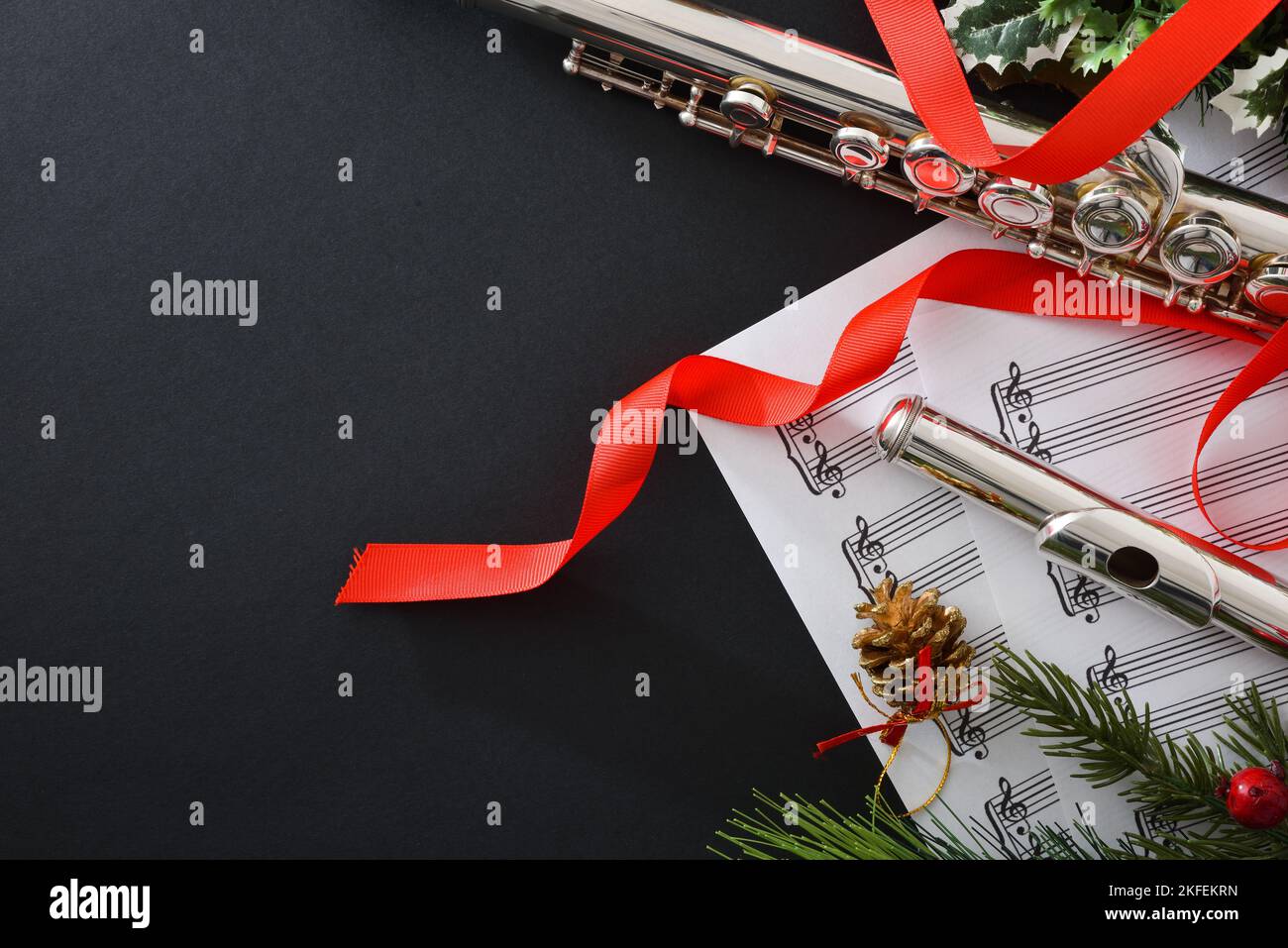 Background with metal flute on black table with Christmas decoration