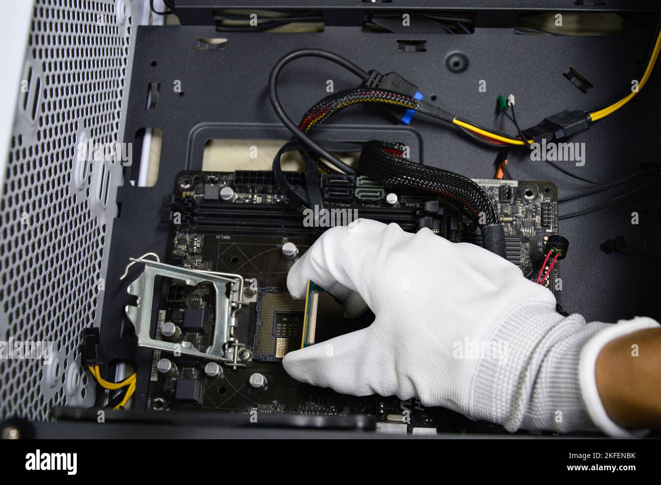 Image of a technician inserting a CPU chip onto a computer motherboard Stock Photo Alamy