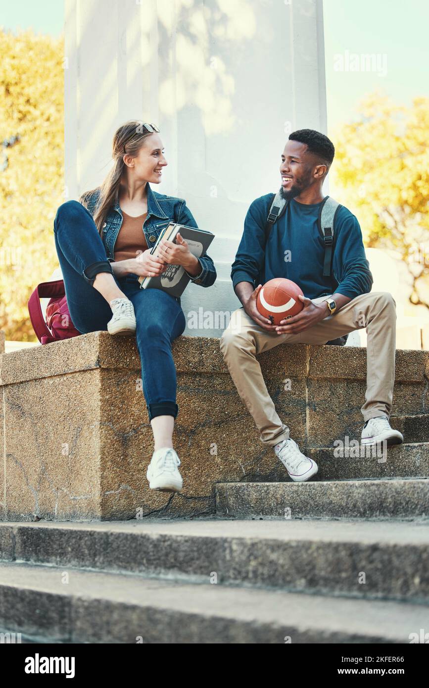 Students, relax and friends in college park for study, education and happy learning. University, woman with books and african sports man or university Stock Photo