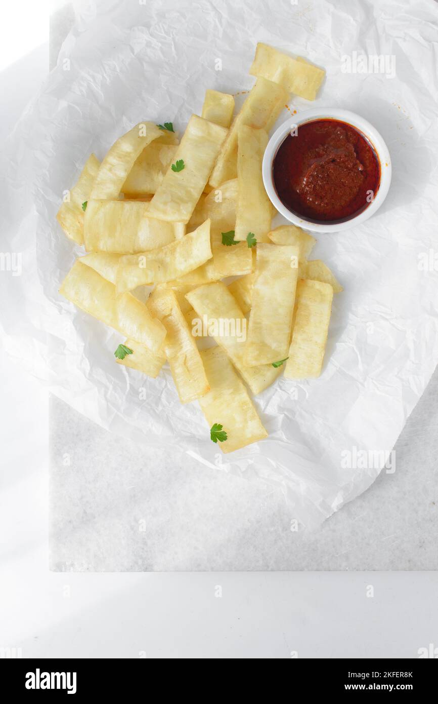 slices of fried yam and sauce, slices fried yam and stew on parchment