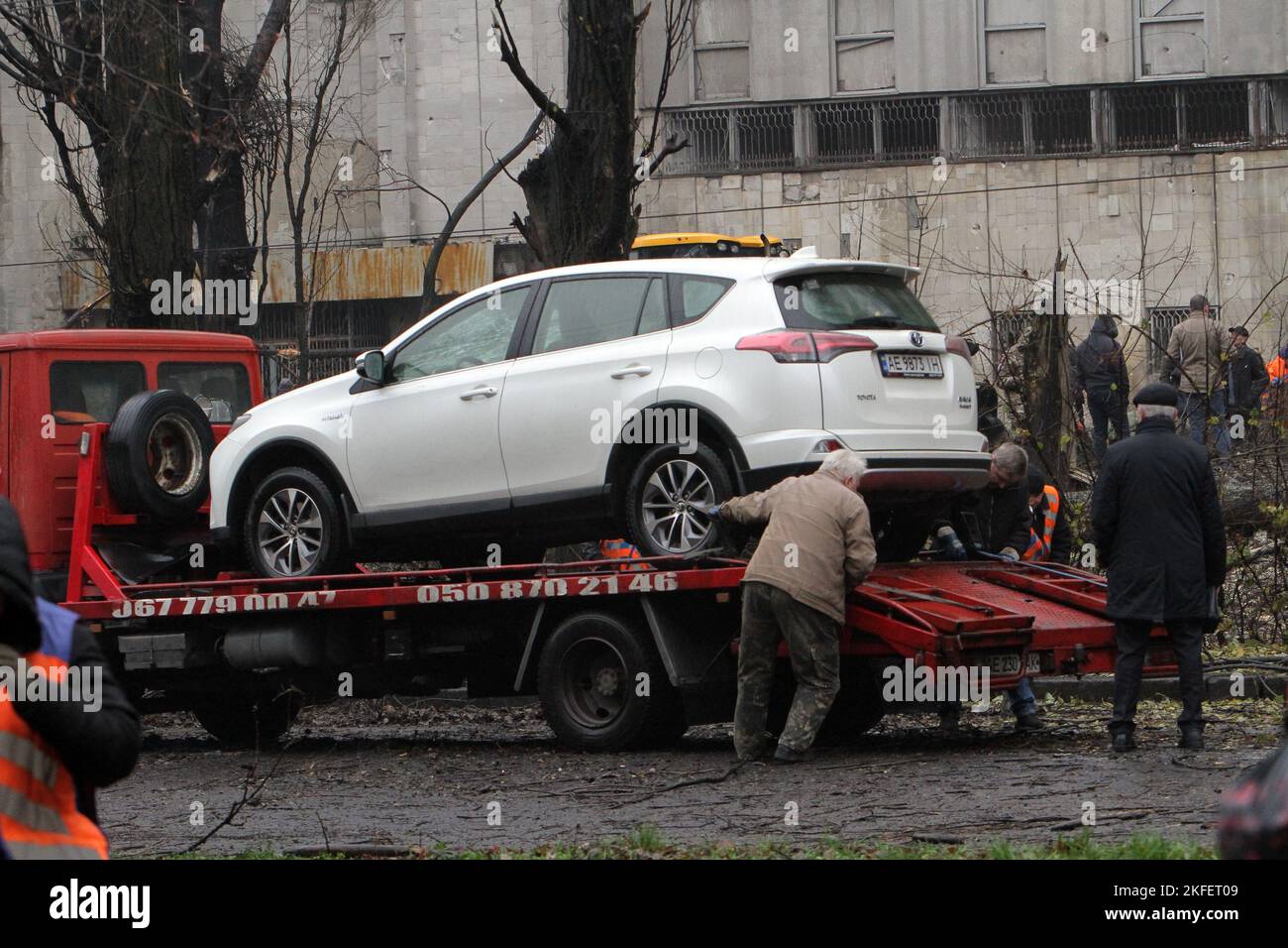 DNIPRO, UKRAINE - NOVEMBER 17, 2022 - A tow truck takes away a car damaged by a Russian missile strike on the city in the morning, Dnipro, eastern Ukraine. Stock Photo