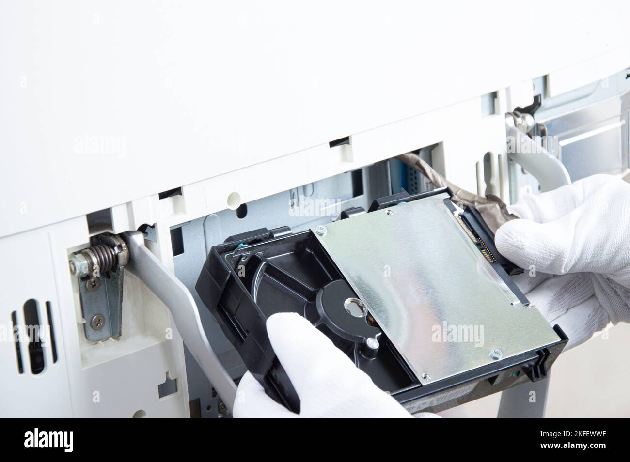 3.5 inch hard drive that technician is installing in computer Stock