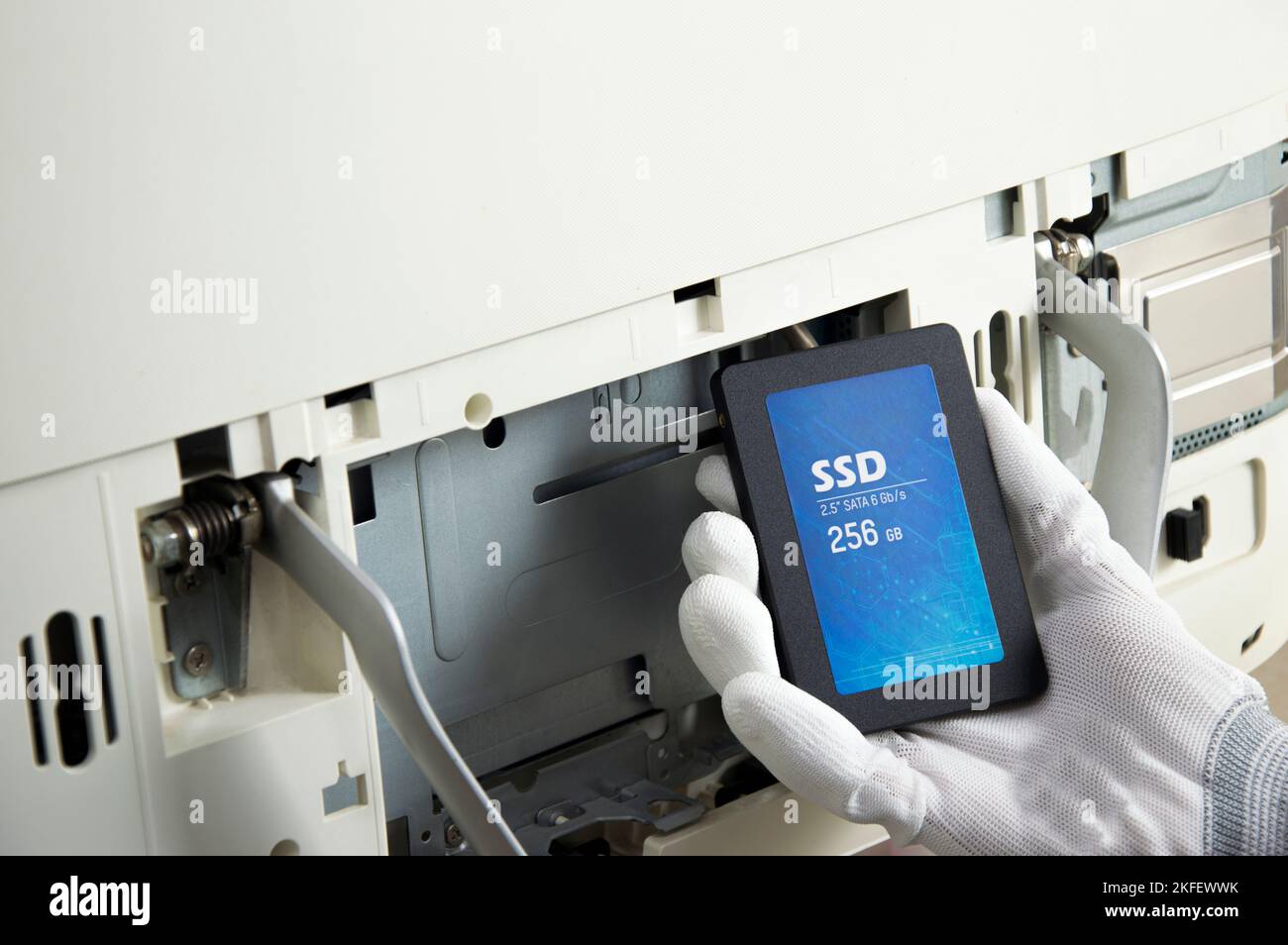 2.5 inch ssd hard drive that technician is installing in computer Stock Photo