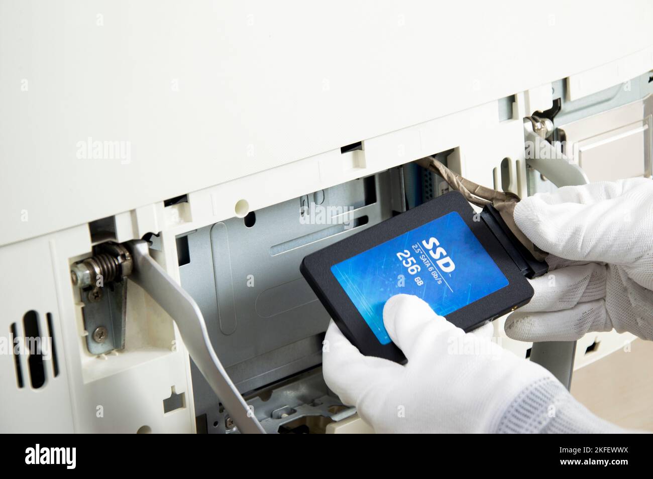 2.5 inch ssd hard drive that technician is installing in computer Stock Photo