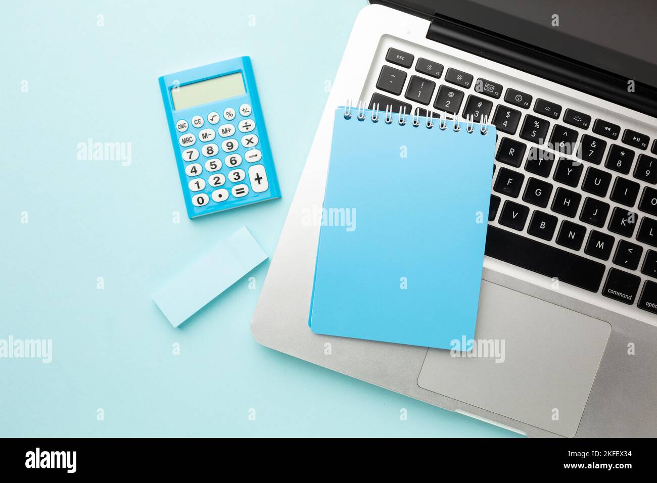 Office desk table with laptop computer, notebook, calculator, eraser
