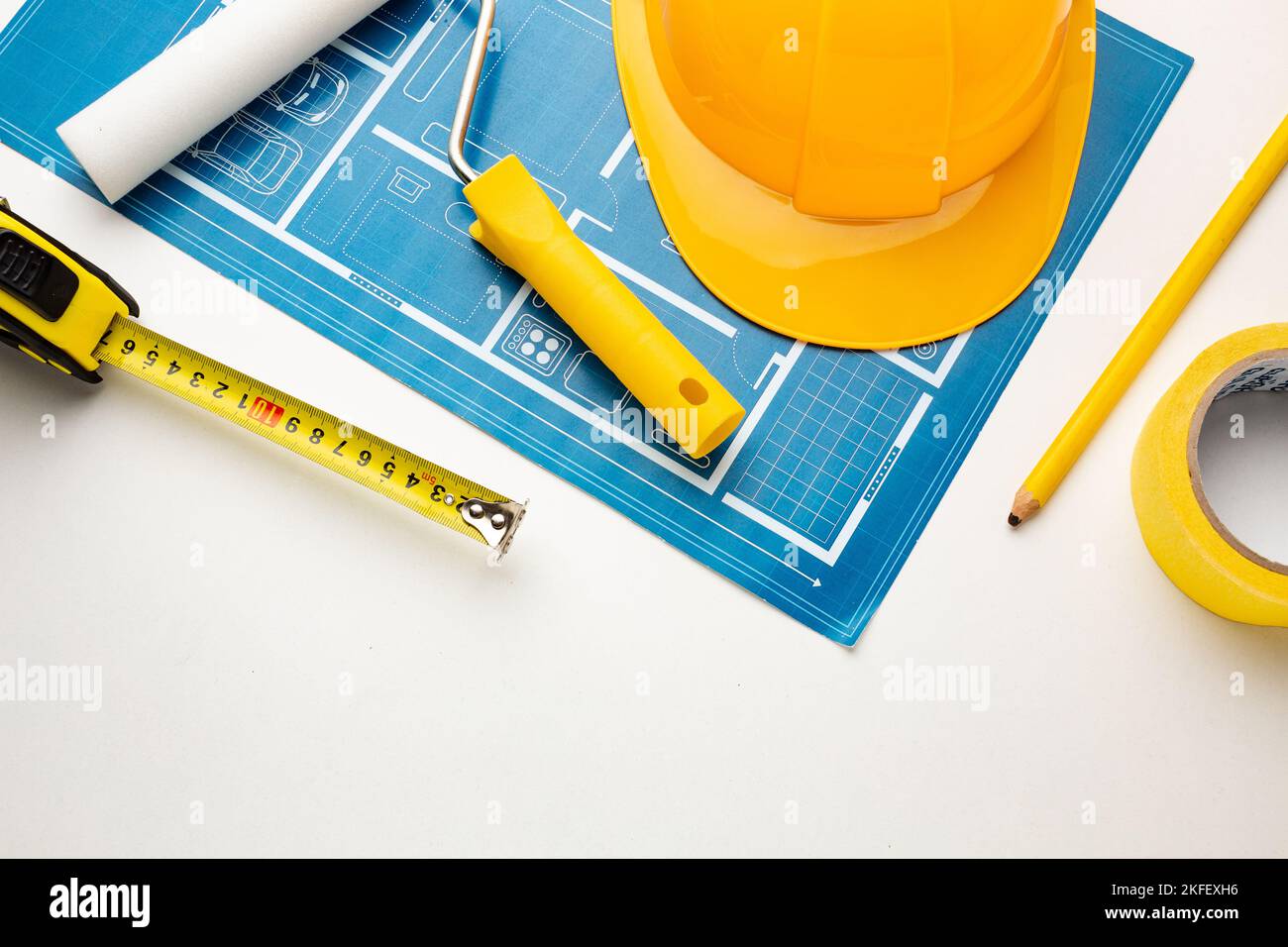 Floor plan, hard hat, tape measure, construction tools on a white ...