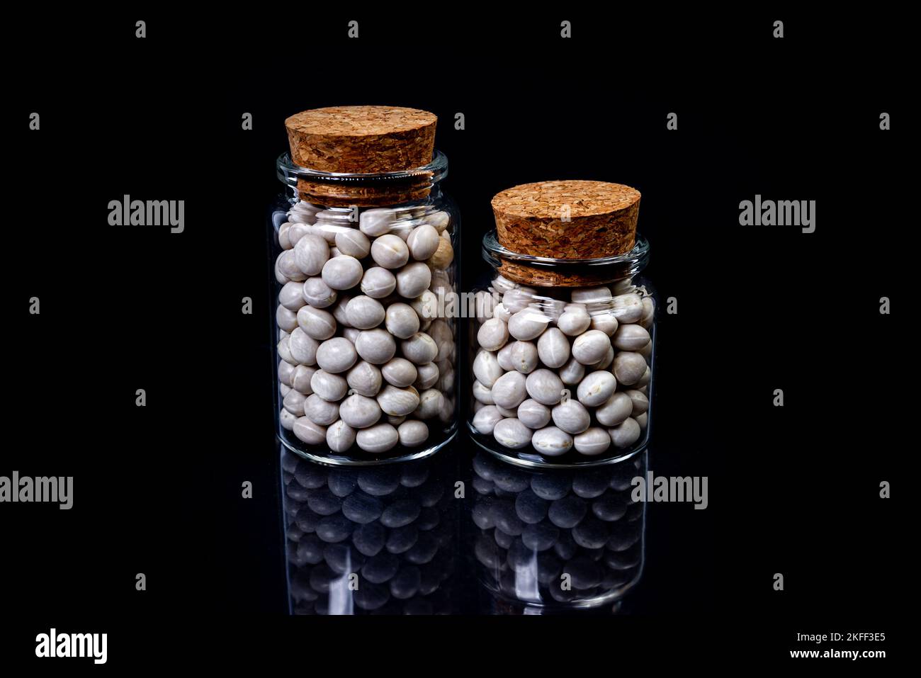 raw white beans in glass jar, wine glass. in bucket. raw white beans on