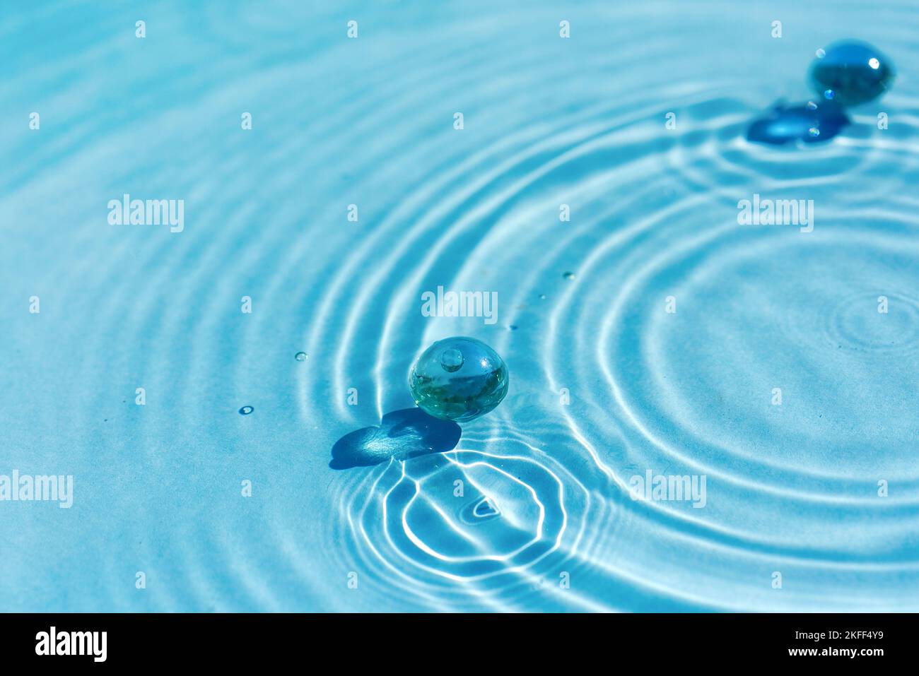 Water blue abstract background with ripples, circles, with granules and collagen Concept for cosmetic background and SPA for skin care Stock Photo