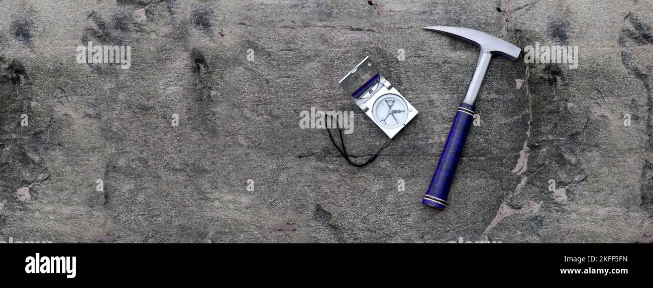 banner-geology mine exploration with compass on stone and hammer