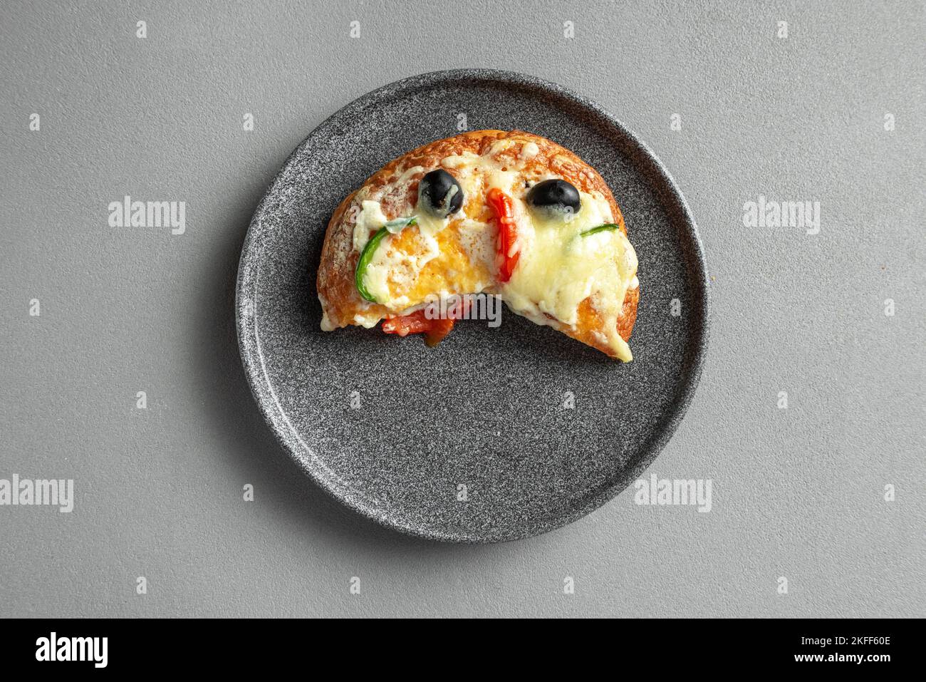 Slice of Indian pizza on a plate on a gray background Stock Photo