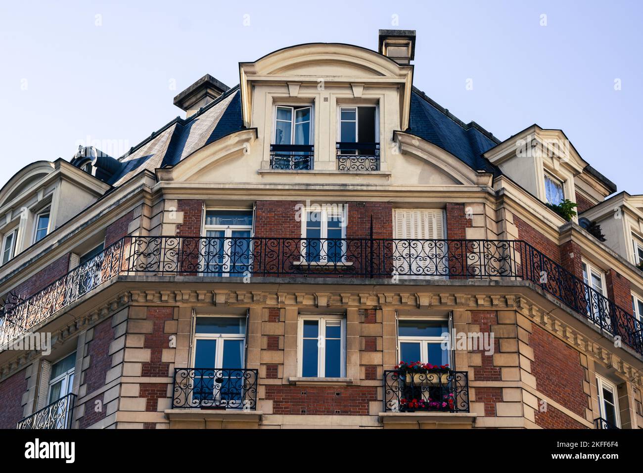 The facades of a modernized medieval building before the blue sky in Paris Stock Photo