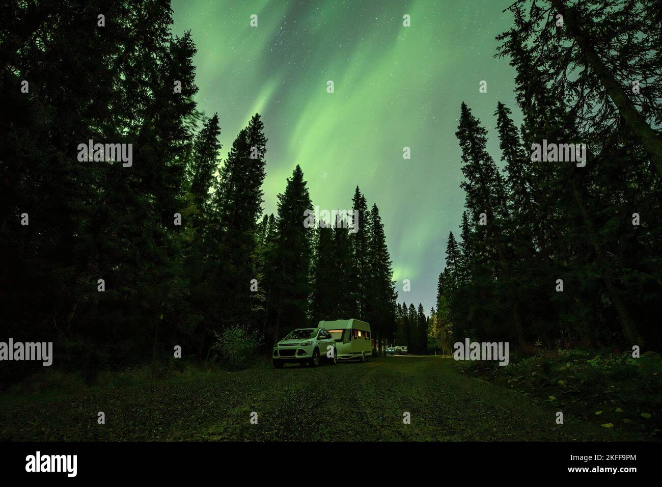 Aurora shining over Camping Caravan in Swedish forest landscape