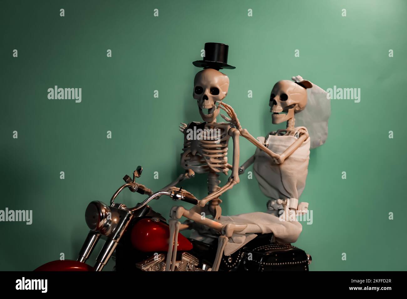 Happily married skeleton couple taking a photo on a motorcycle Stock Photo