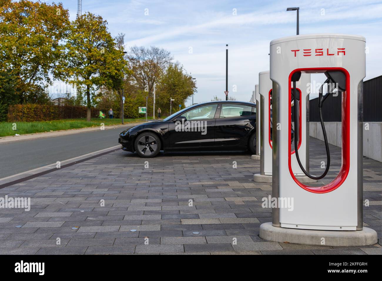 A row of the Tesla Superchargers with a black charging Tesla car