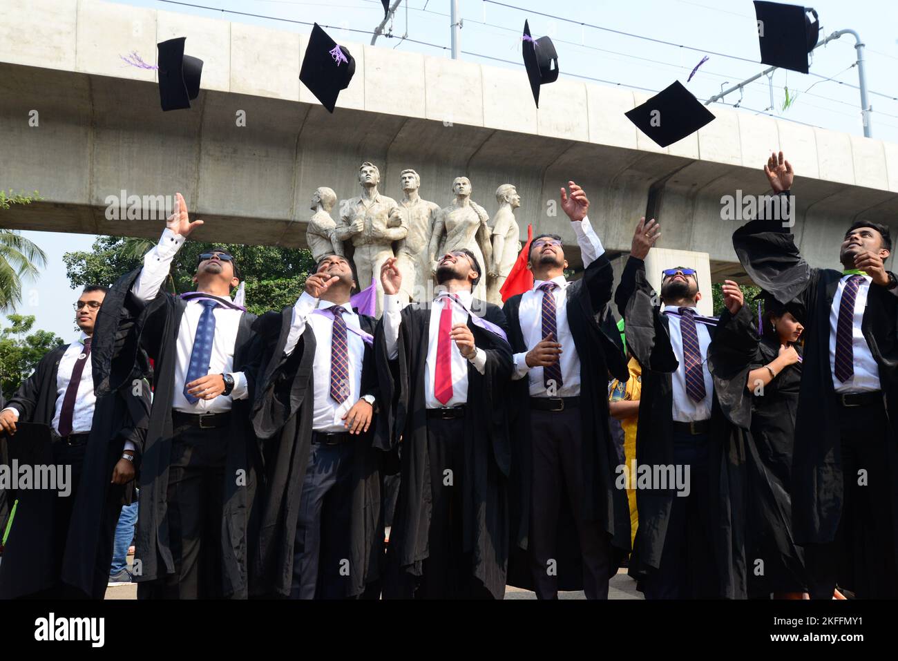 A group of graduates expressing their delight in front of the sculpture ...