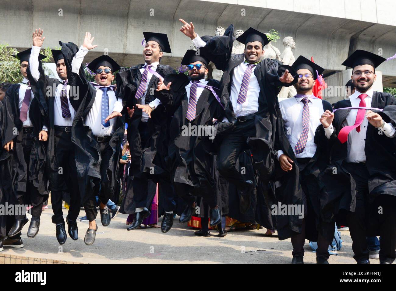 A group of graduates expressing their delight in front of the sculpture ...