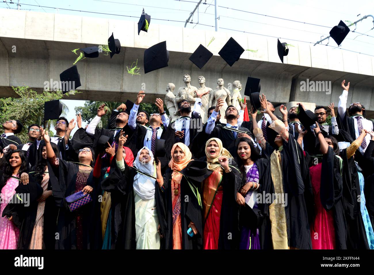 A group of graduates expressing their delight in front of the sculpture ...