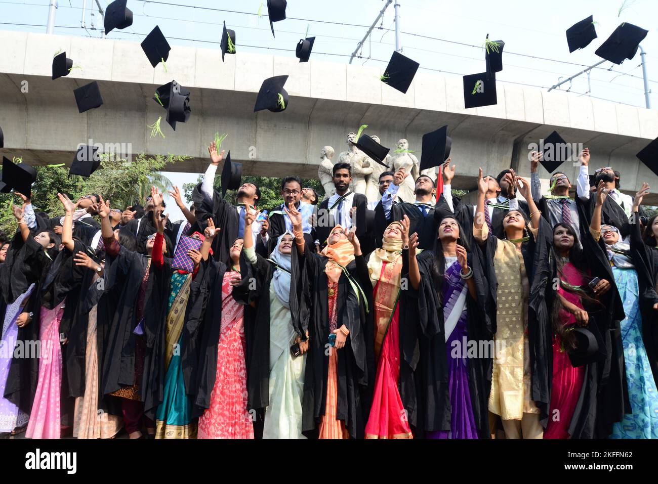 A group of graduates expressing their delight in front of the sculpture ...