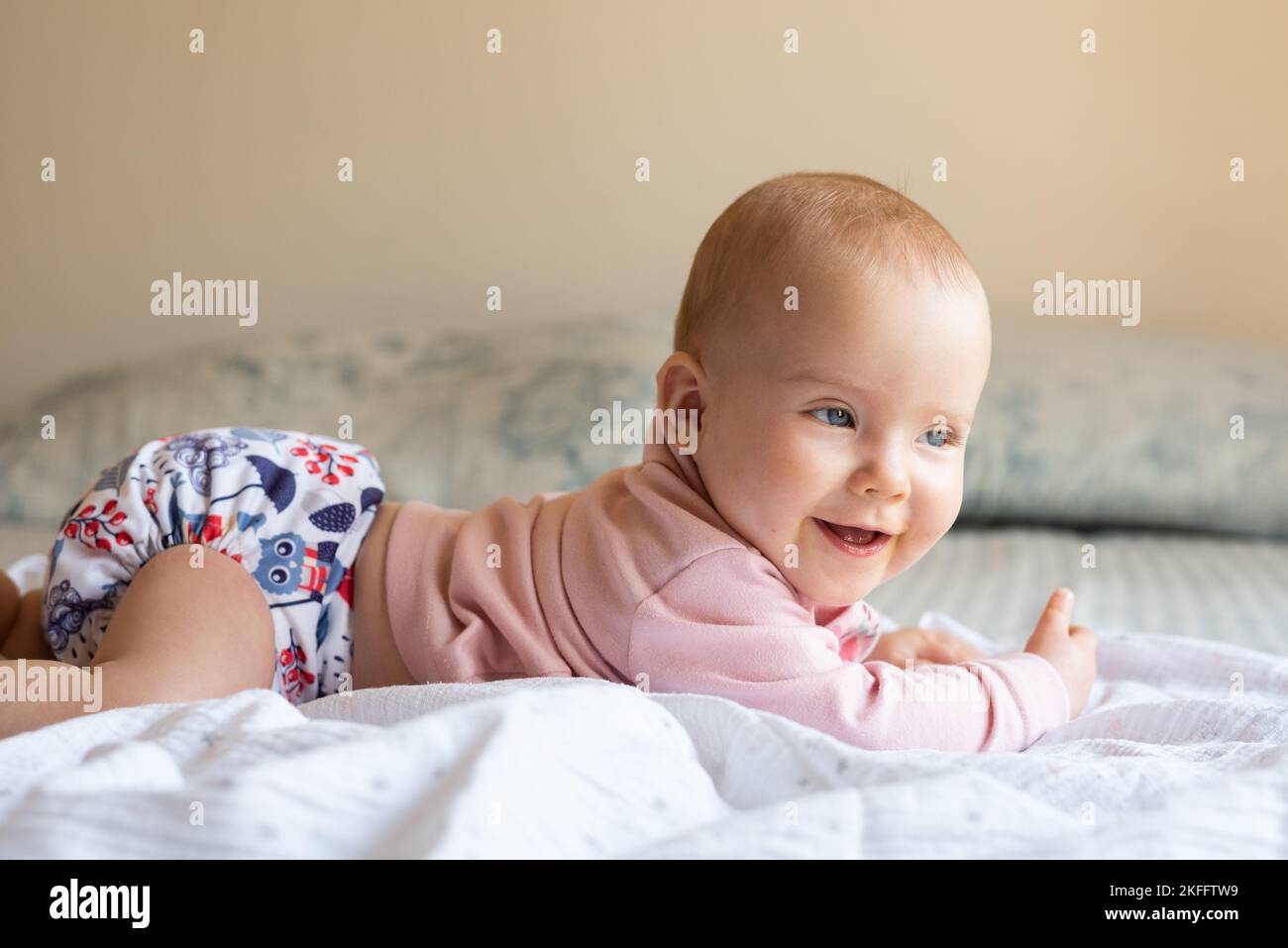 A baby girl lying on her stomach doing tummy time to strengthen her