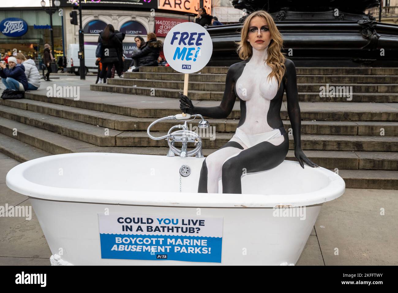 London, UK.  18 November 2022. Love Island star Faye Winter is body-painted as an orca and sits in a cramped bathtub in Piccadilly Circus urging British holidaymakers to skip marine parks that hold orcas and other dolphins in tanks that, to them, are the size of a bathtub.  She will also send a letter to Jet2holiday, an official partner of Love Island, calling on the company to “do the right thing” and stop promoting and selling tickets to marine parks.   Credit: Stephen Chung / EMPICS / Alamy Live News Stock Photo