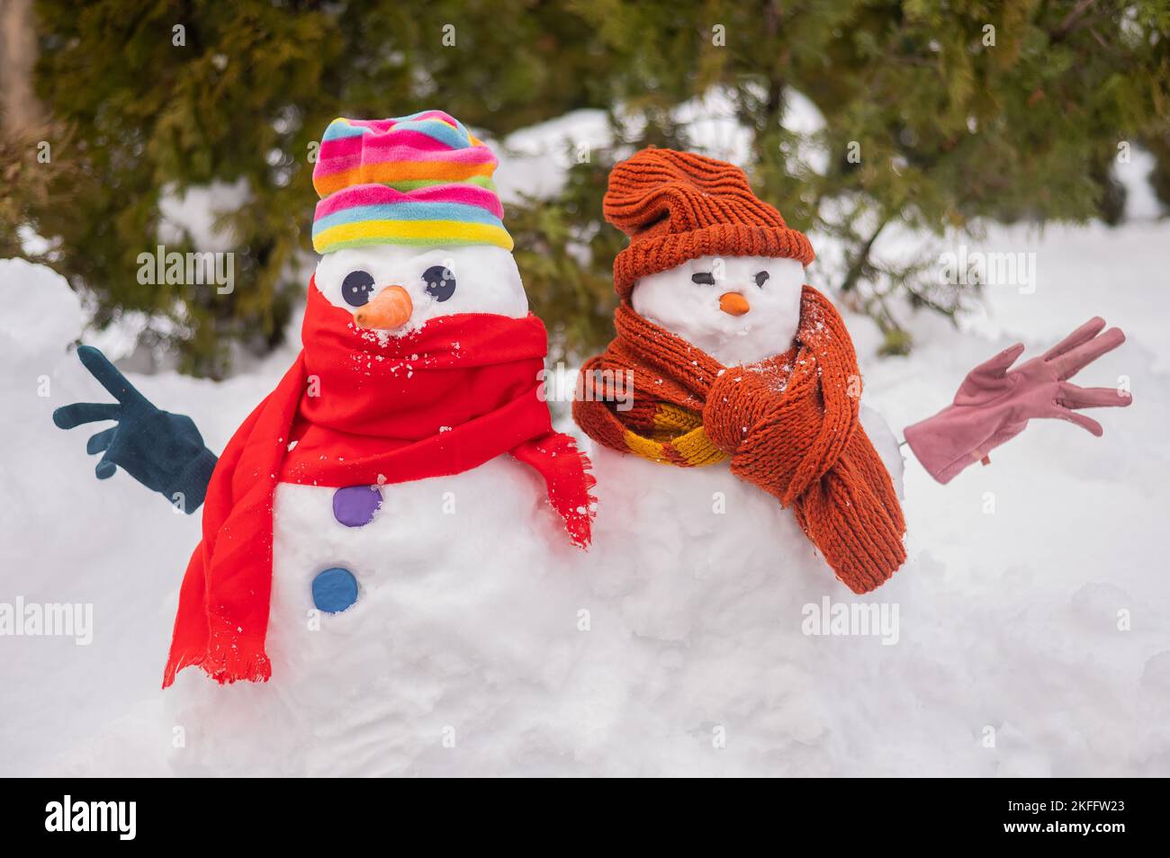 A couple of snowmen in hats and scarves. Winter fun Stock Photo - Alamy