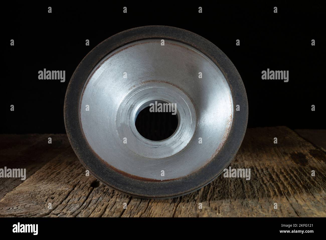 A locksmith tool for grinding on an old wooden table. Industrial objects on a dark background Stock Photo