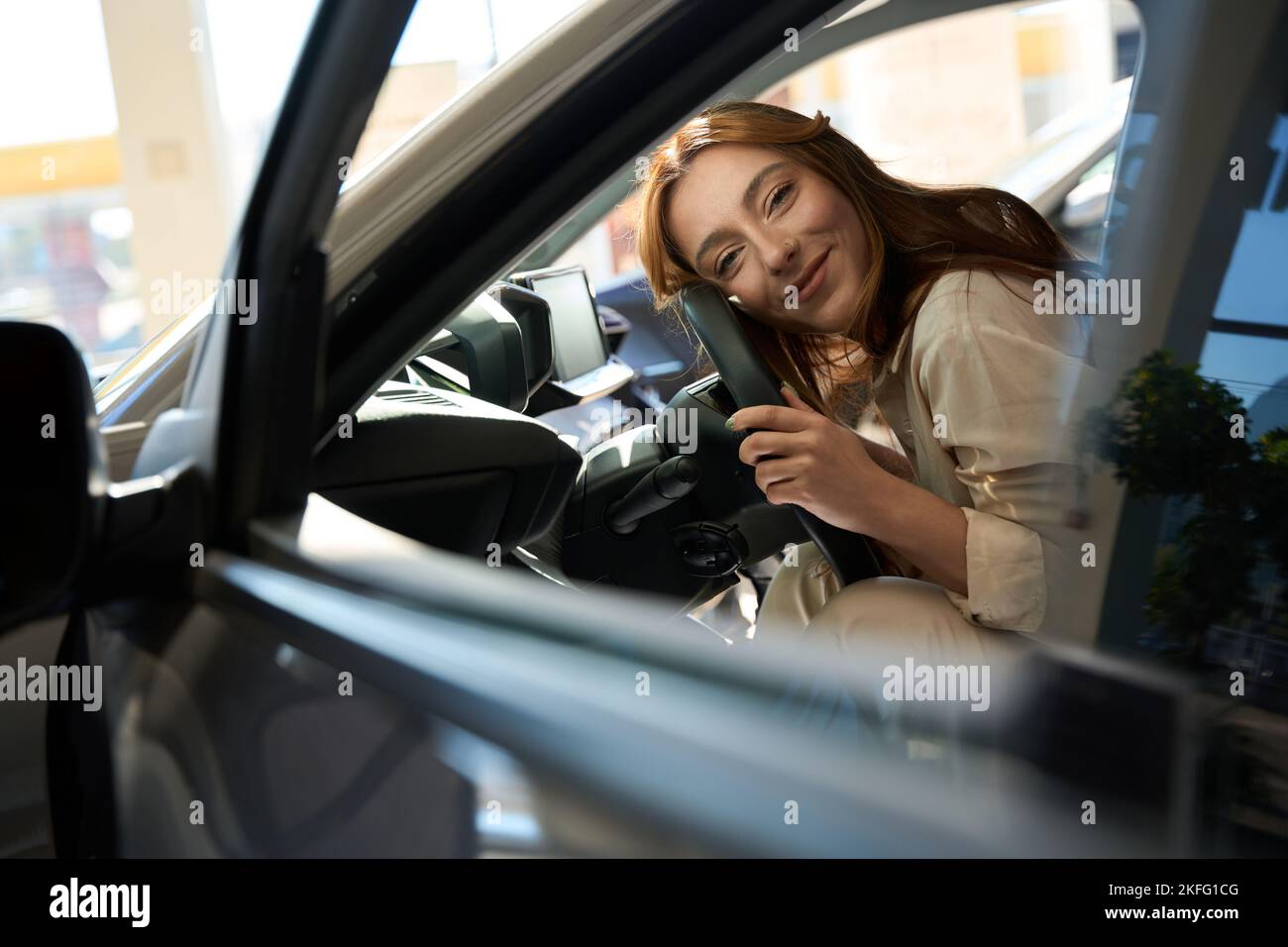 Happy female buyer lying in new car Stock Photo