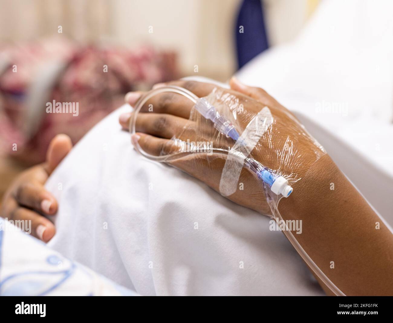 A pregnant woman in labor, lying in a hospital bed waiting for her baby to be born. Stock Photo