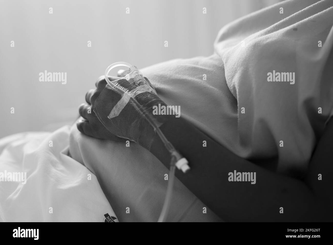 A pregnant woman in labor, lying in a hospital bed waiting for her baby to be born. Stock Photo