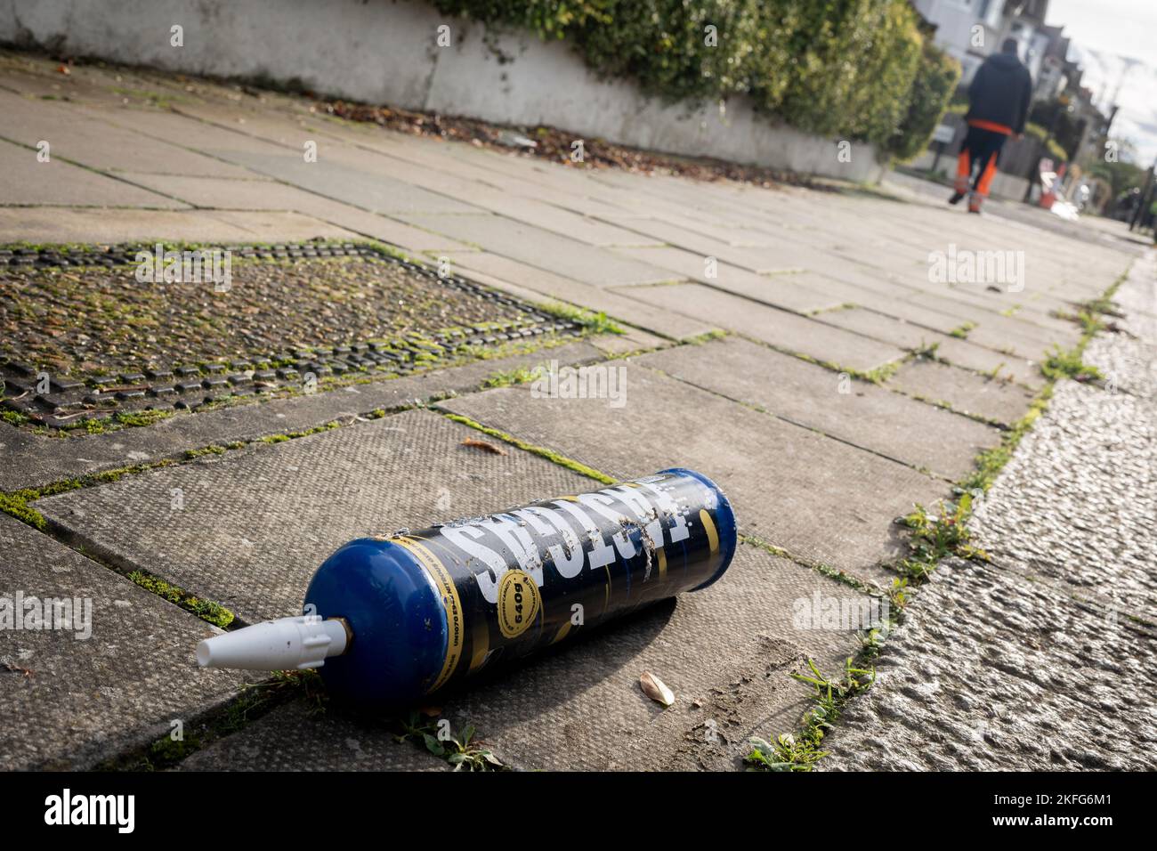 A Fast Gas nitrous oxide cylinder lies on the pavement of a surburban