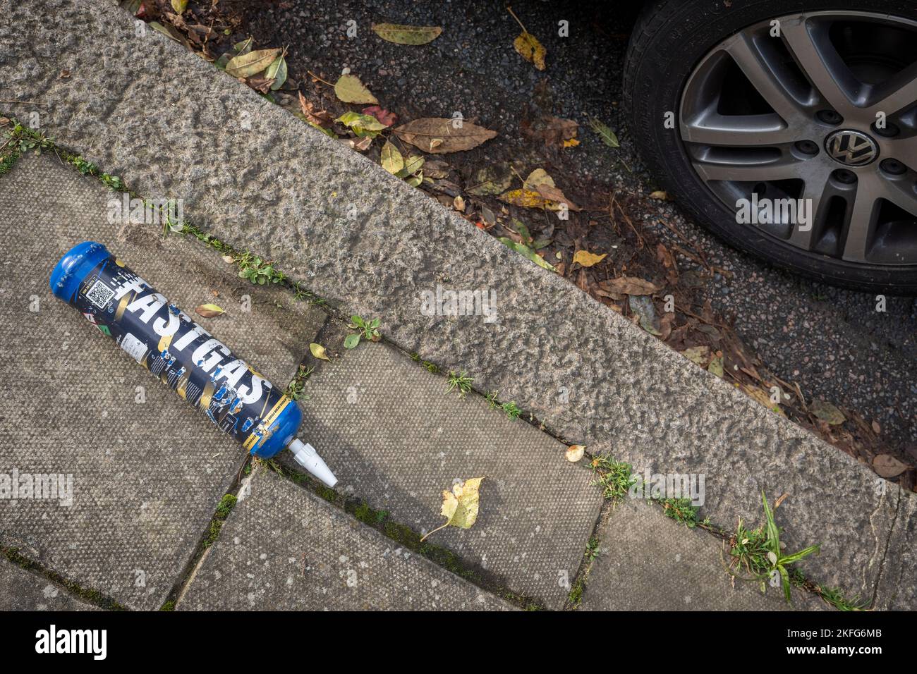 A Fast Gas nitrous oxide cylinder lies nest to a parked car on the