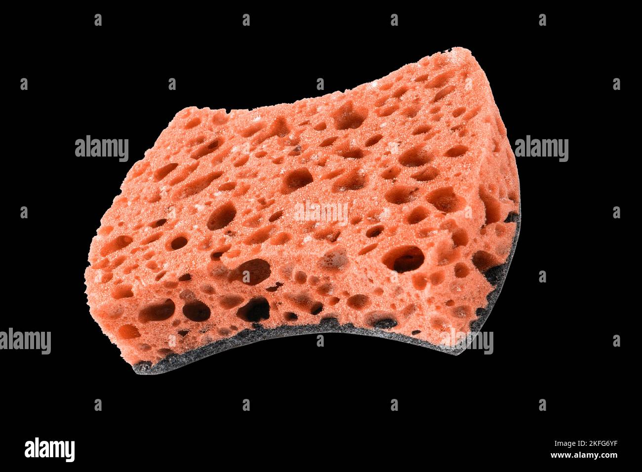 Macro shot of a surface of plastic red sponge isolated on black background. Close-up texture. Yellow scrub sponge. Sponge texture background. Yellow s Stock Photo