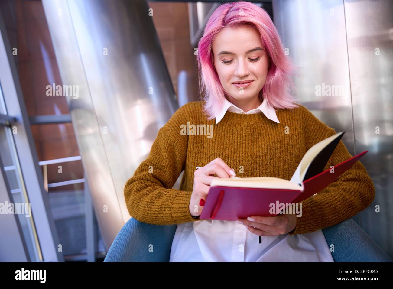 Smiling female making notes in the book Stock Photo