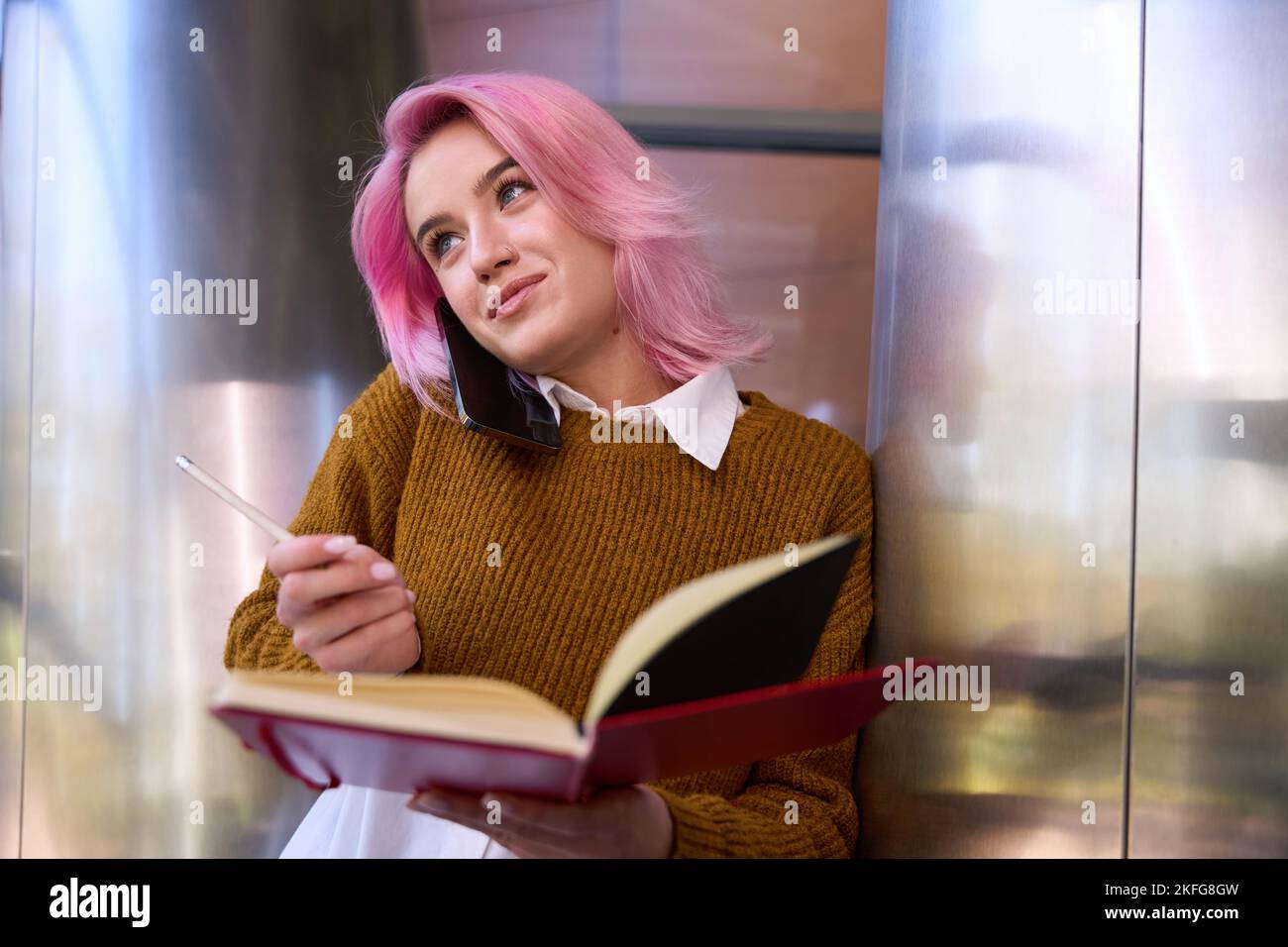 Female making notes and talking on the phone Stock Photo