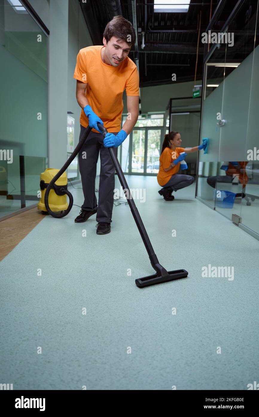 Hard-working man in uniform tidying the floor in the building Stock Photo